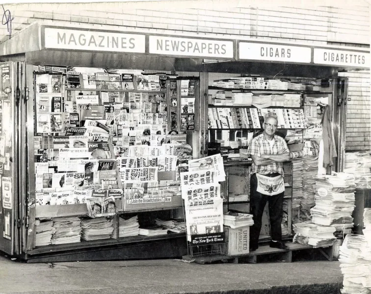 May be a black-and-white image of newsstand, street and text
